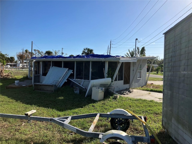 back of house with a yard and a sunroom