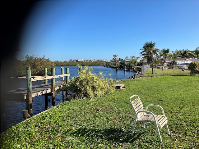 dock area with a water view and a yard