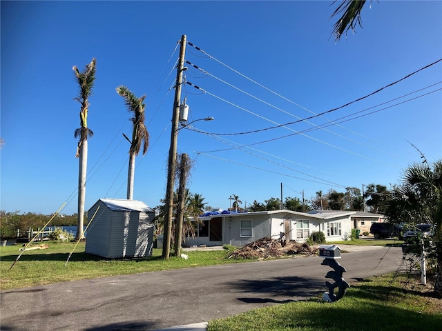 view of front facade featuring a front yard and a storage unit