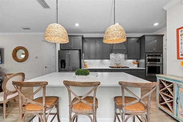 kitchen featuring custom exhaust hood, decorative light fixtures, stainless steel appliances, and a breakfast bar