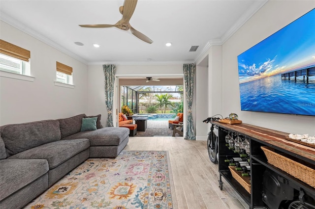 living room featuring light hardwood / wood-style flooring, ceiling fan, and crown molding