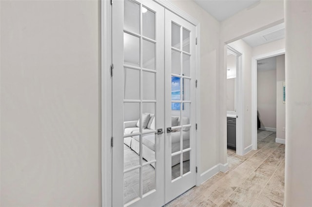 corridor with french doors and light wood-type flooring