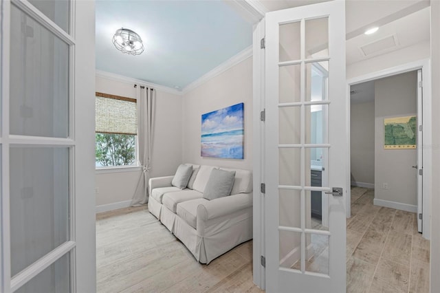 living area with ornamental molding and light wood-type flooring