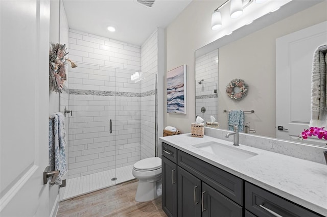 bathroom featuring vanity, toilet, wood-type flooring, and an enclosed shower