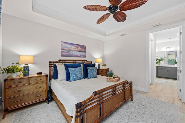 bedroom with ensuite bathroom, crown molding, light wood-type flooring, and ceiling fan