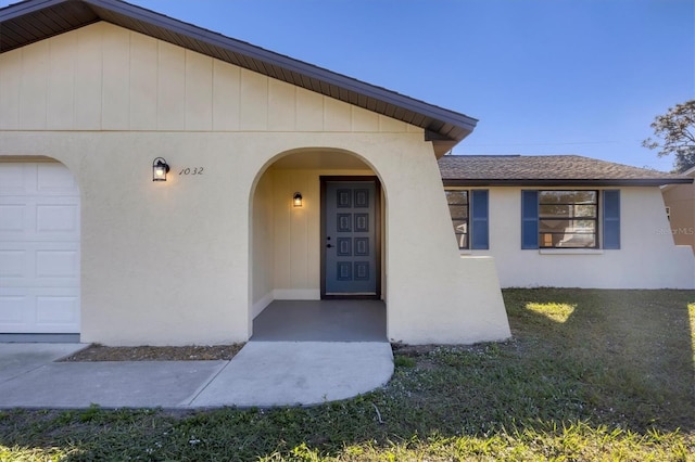 doorway to property featuring a lawn and a garage