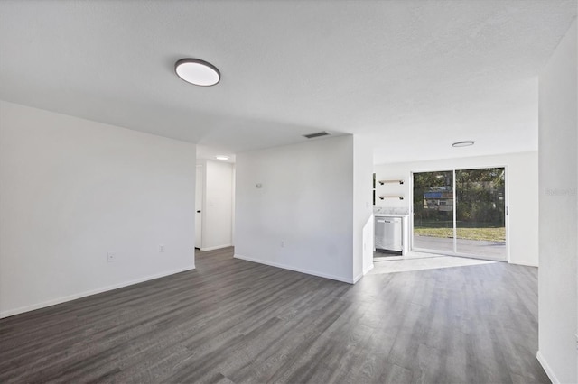 empty room featuring a textured ceiling and dark hardwood / wood-style flooring