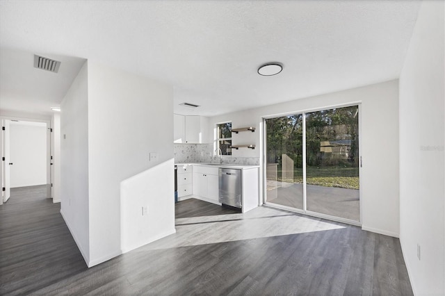 kitchen featuring dishwasher, dark wood-type flooring, sink, tasteful backsplash, and white cabinetry