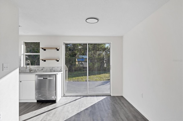 interior space with dishwasher, sink, white cabinetry, and dark wood-type flooring