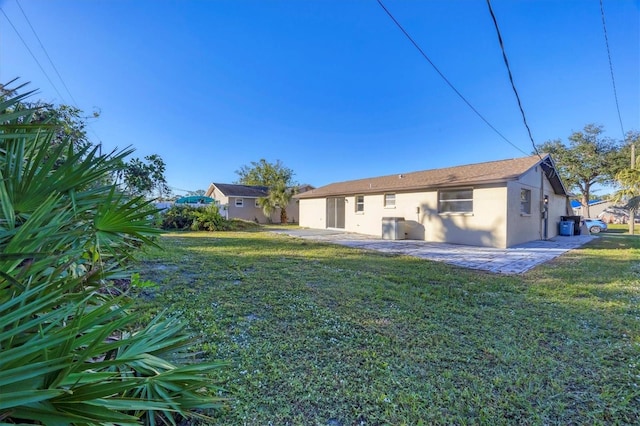 back of property with a lawn and a patio area