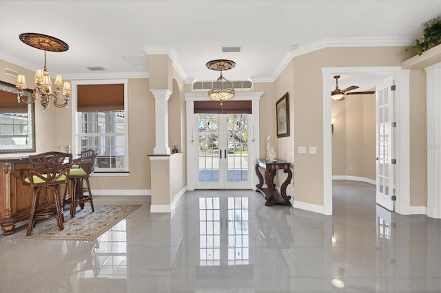 entrance foyer featuring french doors, ornamental molding, ceiling fan with notable chandelier, and decorative columns