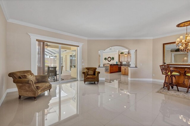 living area with an inviting chandelier, crown molding, and light tile patterned floors