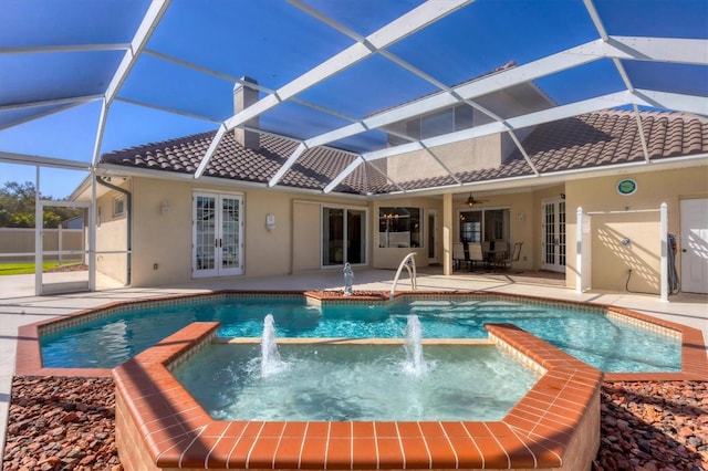 view of pool featuring an in ground hot tub, ceiling fan, pool water feature, and glass enclosure