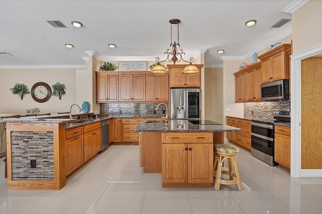 kitchen featuring ornamental molding, an island with sink, stainless steel appliances, and light tile patterned floors