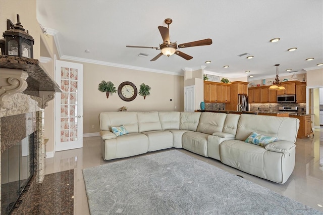 tiled living room featuring a premium fireplace, ornamental molding, and ceiling fan