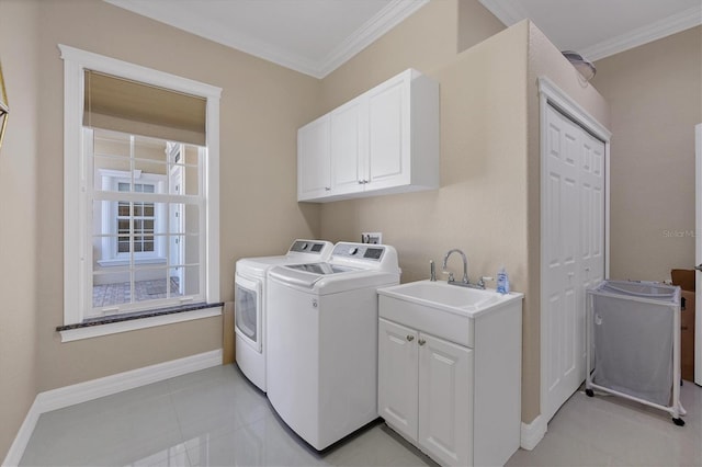 clothes washing area featuring ornamental molding, washer and dryer, sink, and cabinets