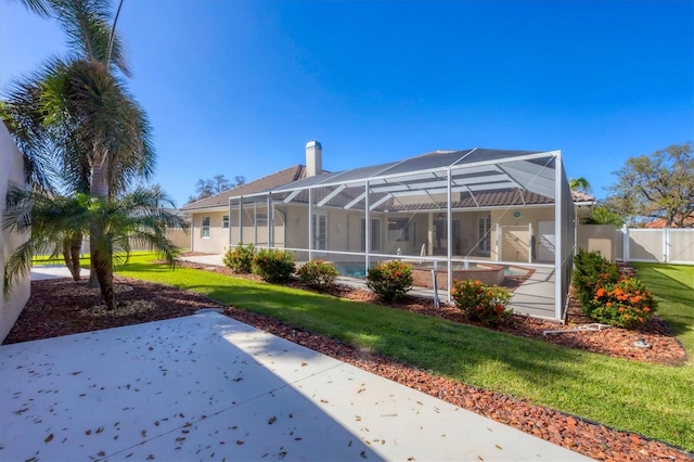 back of house featuring a patio, a yard, and glass enclosure