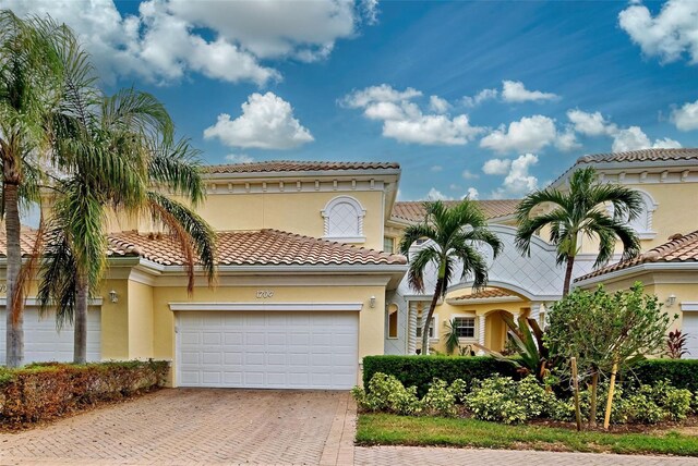 1704 Triano Cir Unit 1704, Venice, FL 34292 - mediterranean / spanish home featuring decorative driveway, stucco siding, a garage, and a tile roof