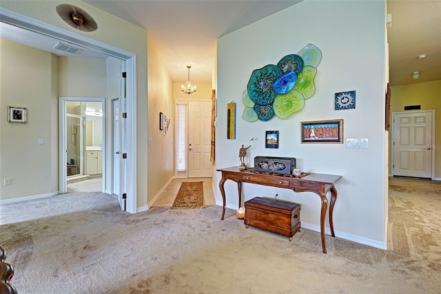 foyer with light carpet and a notable chandelier