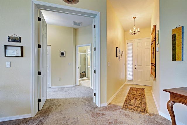 entryway featuring a notable chandelier and light colored carpet