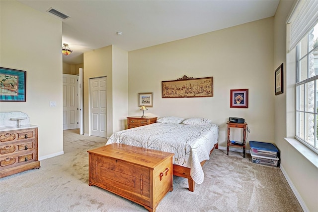 carpeted bedroom with a closet and multiple windows