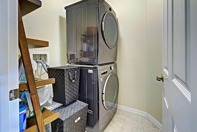 1704 Triano Cir Unit 1704, Venice, FL 34292 - clothes washing area with stacked washer / dryer, baseboards, light tile patterned floors, and a textured wall