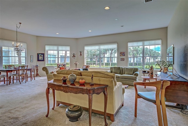 living room with an inviting chandelier, a healthy amount of sunlight, and light colored carpet