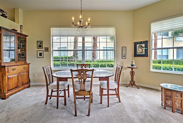 dining room featuring light carpet, an inviting chandelier, and plenty of natural light