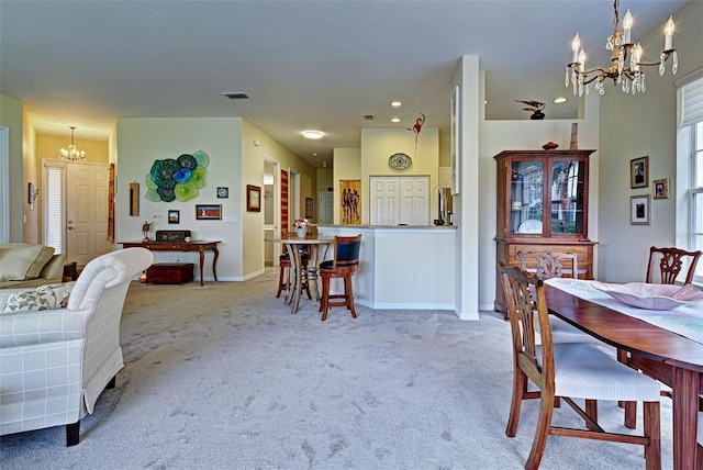 carpeted dining space featuring a chandelier