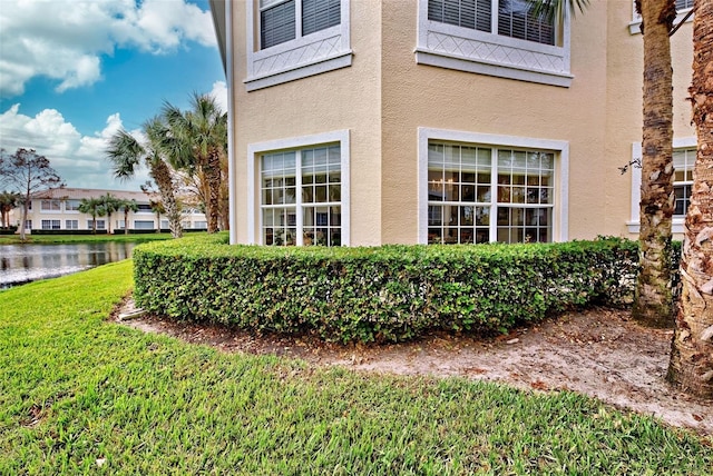 exterior space featuring a water view and a yard