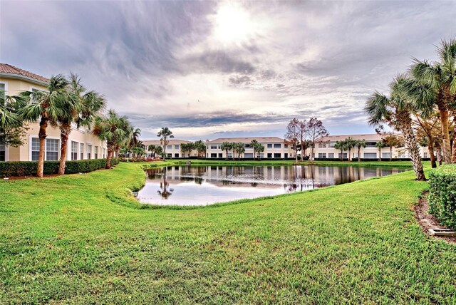 view of property's community with a yard and a water view