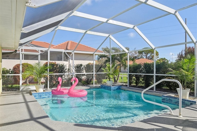 view of swimming pool with glass enclosure and a patio area