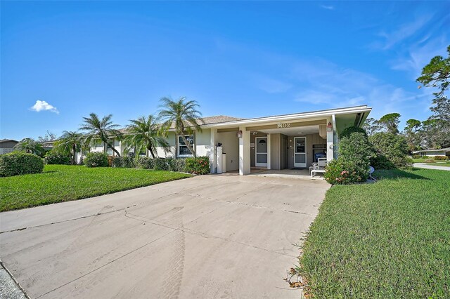 1402 Grand Blvd Unit 240, Sarasota, FL 34232 - view of front of house with driveway, a front yard, a carport, and stucco siding