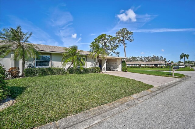 1402 Grand Blvd Unit 240, Sarasota, FL 34232 - ranch-style home featuring driveway, a front yard, stucco siding, and a carport