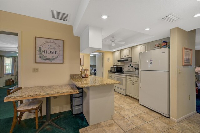 1402 Grand Blvd Unit 240, Sarasota, FL 34232 - kitchen with white appliances, a peninsula, a ceiling fan, a breakfast bar area, and under cabinet range hood
