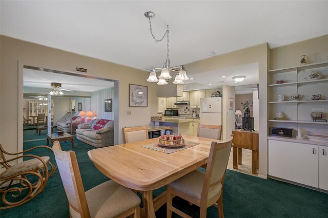1402 Grand Blvd Unit 240, Sarasota, FL 34232 - dining space featuring dark colored carpet, a ceiling fan, and a chandelier