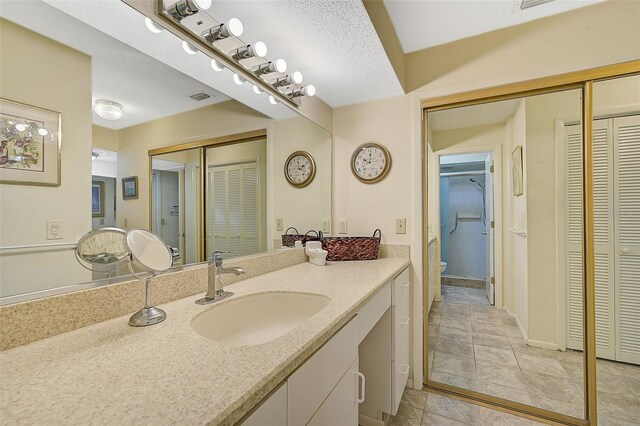 1402 Grand Blvd Unit 240, Sarasota, FL 34232 - full bath featuring a closet, vanity, toilet, stone finish flooring, and baseboards
