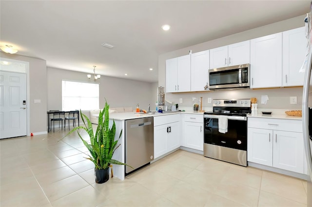 kitchen featuring white cabinets, stainless steel appliances, and light tile patterned floors