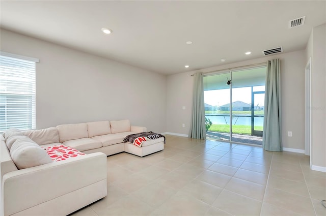 tiled living room with a water view and a healthy amount of sunlight