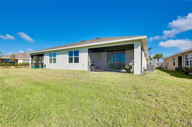 rear view of property featuring a yard and central AC