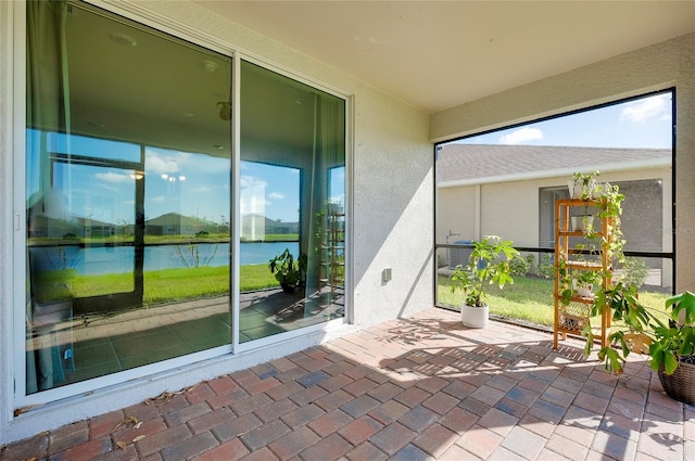 unfurnished sunroom featuring a water view