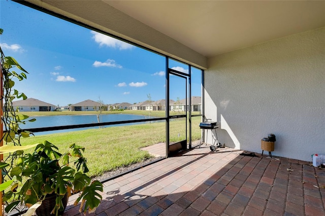 unfurnished sunroom featuring a water view