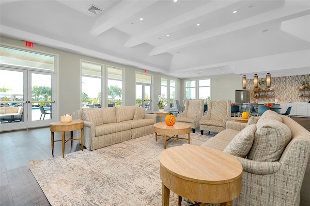 living room featuring hardwood / wood-style floors, beamed ceiling, and french doors