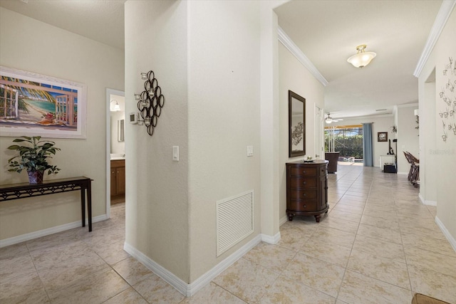 hallway featuring crown molding and light tile patterned floors