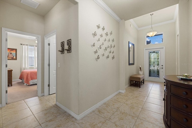 corridor with crown molding, light tile patterned flooring, and plenty of natural light