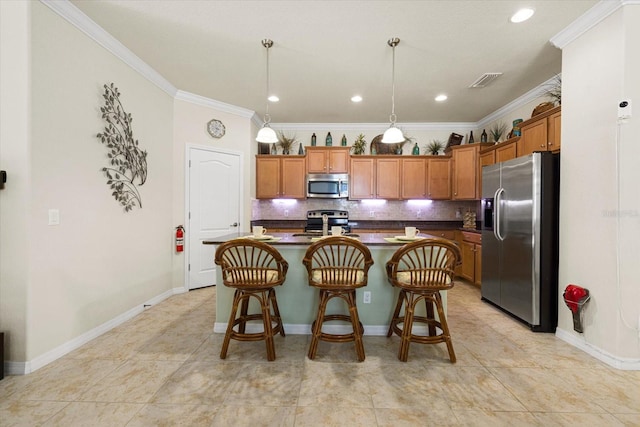 kitchen with tasteful backsplash, appliances with stainless steel finishes, an island with sink, ornamental molding, and a breakfast bar area