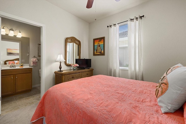 tiled bedroom with connected bathroom, sink, and ceiling fan