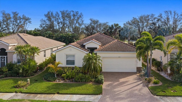 mediterranean / spanish-style home featuring a front lawn and a garage