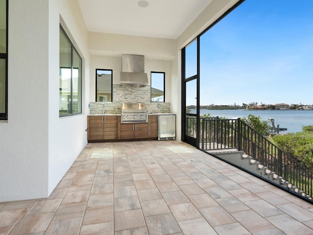 unfurnished sunroom featuring a water view and sink