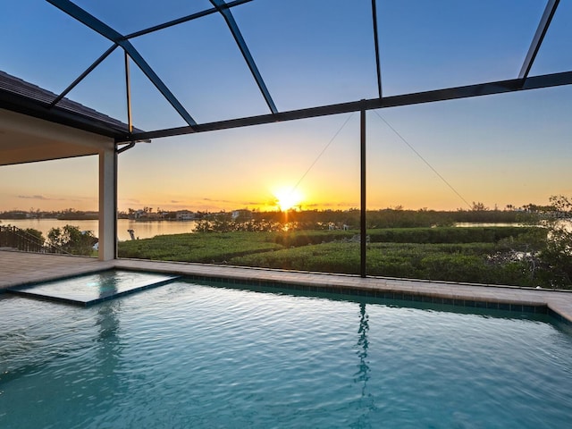 pool at dusk with glass enclosure and a water view